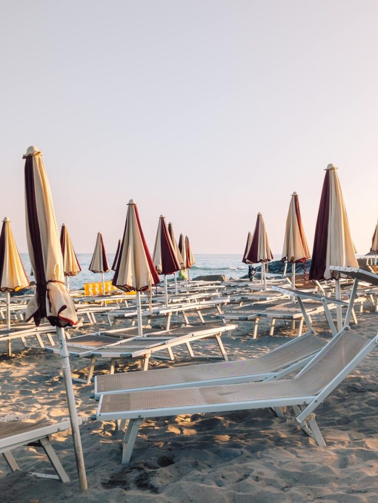 Beach chairs and umbrellas on a sandy shore.