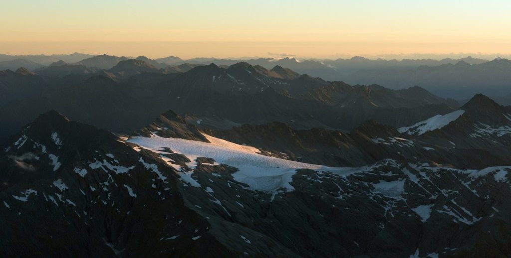 Snow-capped mountains under a hazy sunset sky
